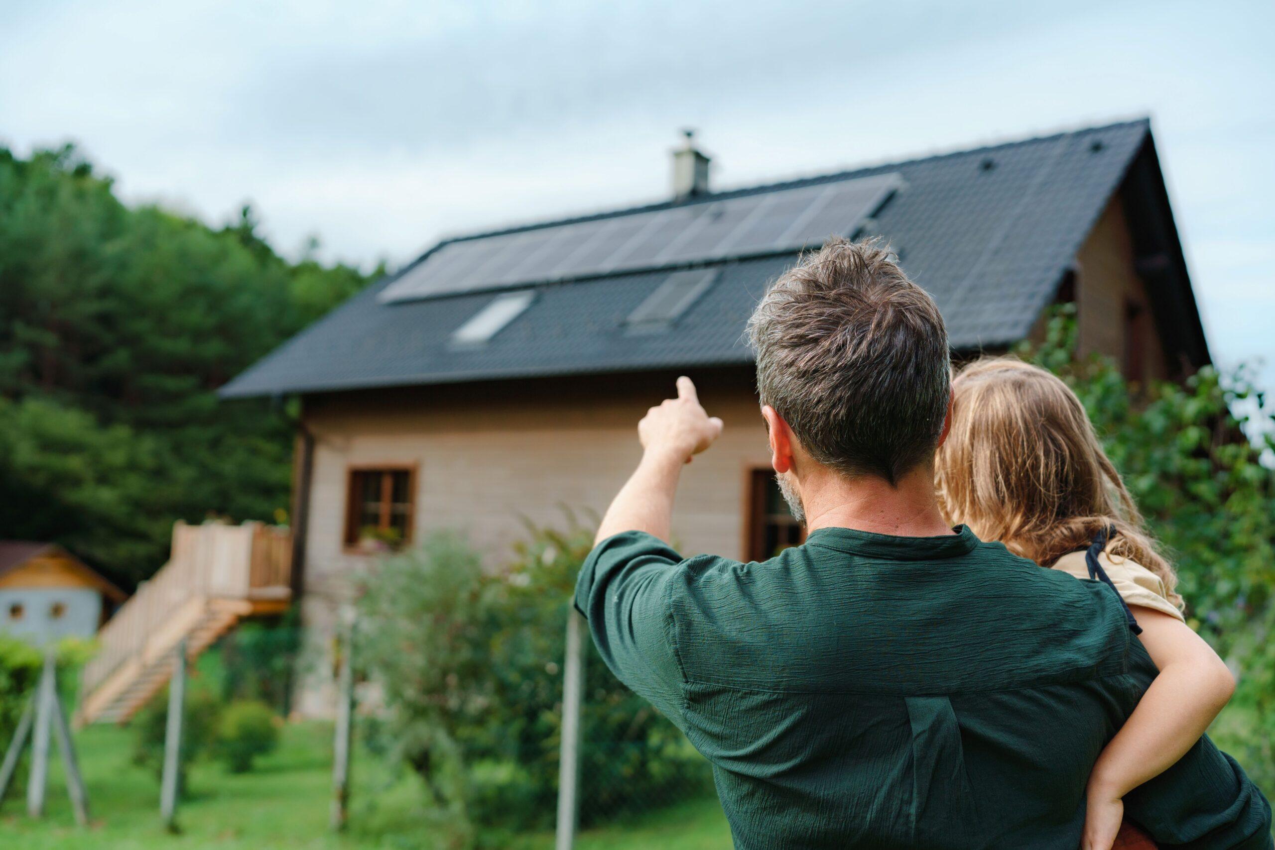 Vater zeigt Tochter eine Solaranlage auf dem Hausdach – Photovoltaik Moers als nachhaltige Investition für Familien